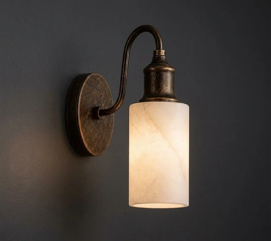 Gooseneck alabaster cylinder wall sconce glowing against a dark charcoal wall
