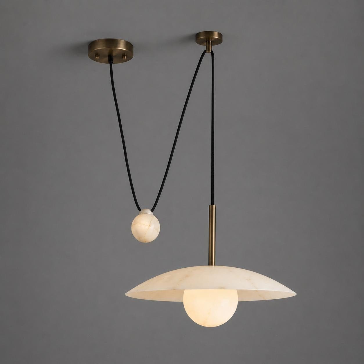 Alabaster double pendant light with a wide disc shade over a glowing alabaster sphere and a second cord with an alabaster counterweight