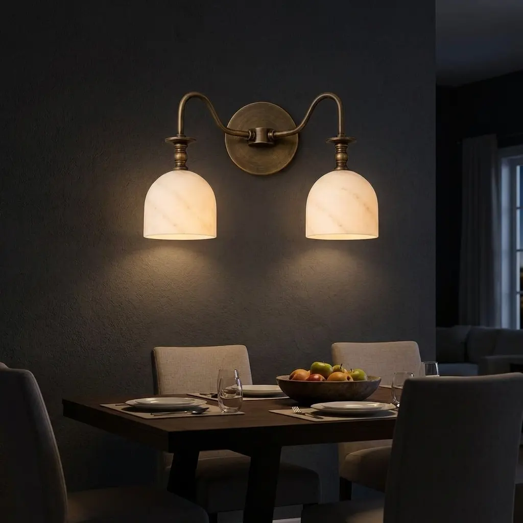 Twin-arm alabaster bell-shade wall sconce lighting a dining room table setting